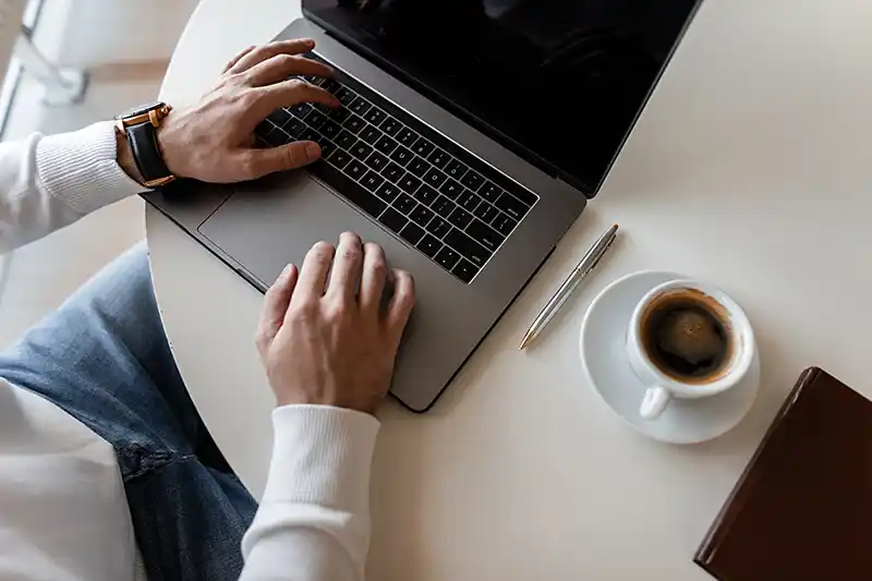 Professional working on laptop joining Peak Utility Brokers affiliate program